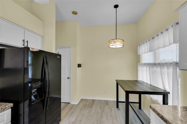 956 Chula Ct, The Villages, FL 32159 - kitchen with white cabinets, black refrigerator with ice dispenser, baseboards, pendant lighting, and light wood-style flooring