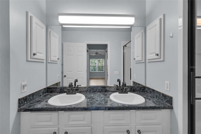 956 Chula Ct, The Villages, FL 32159 - bathroom featuring a shower with shower door, double vanity, a sink, and a ceiling fan