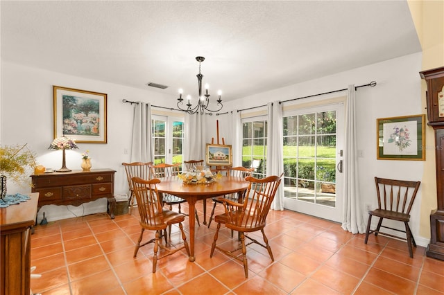 tiled dining area featuring a textured ceiling and an inviting chandelier