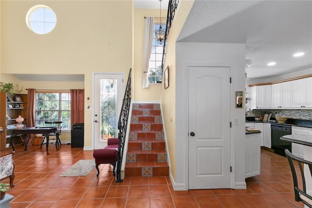 staircase with tile patterned flooring and a textured ceiling