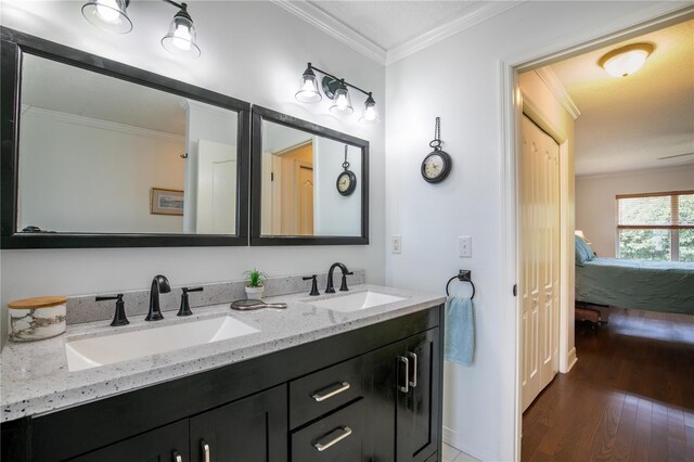 bathroom with hardwood / wood-style floors, vanity, and ornamental molding