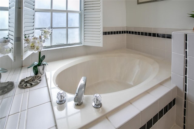 bathroom with tile patterned floors and a relaxing tiled tub