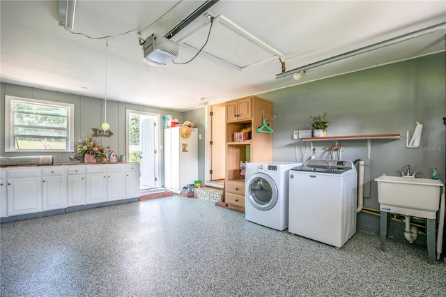 laundry area with cabinets, washing machine and dryer, and sink