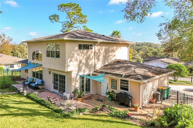 rear view of property featuring a lawn and a patio