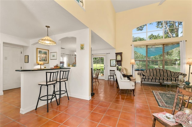 living room featuring tile patterned flooring and a towering ceiling