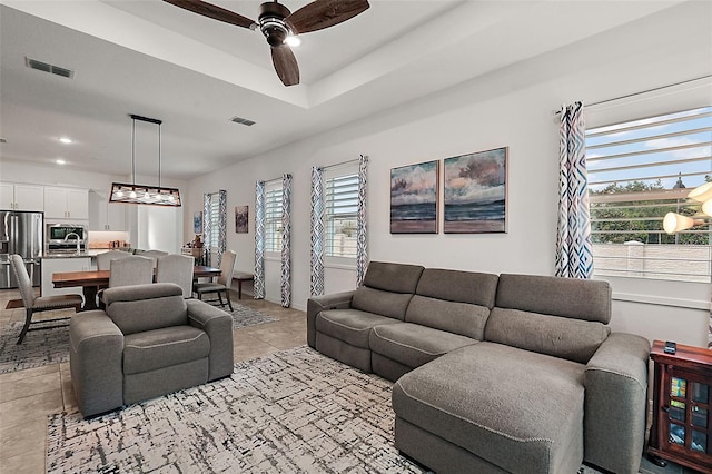 tiled living room with ceiling fan and plenty of natural light