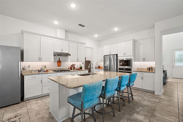 kitchen with white cabinetry, appliances with stainless steel finishes, and a kitchen island with sink