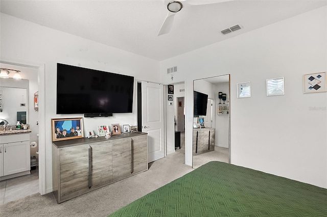 carpeted bedroom featuring ceiling fan and ensuite bath