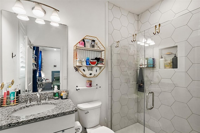 bathroom with a shower with door, vanity, and toilet