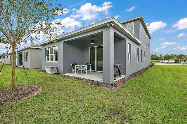 back of property featuring ceiling fan, a lawn, and a patio