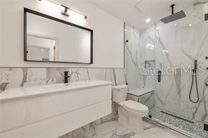 bathroom featuring walk in shower, vanity, and toilet