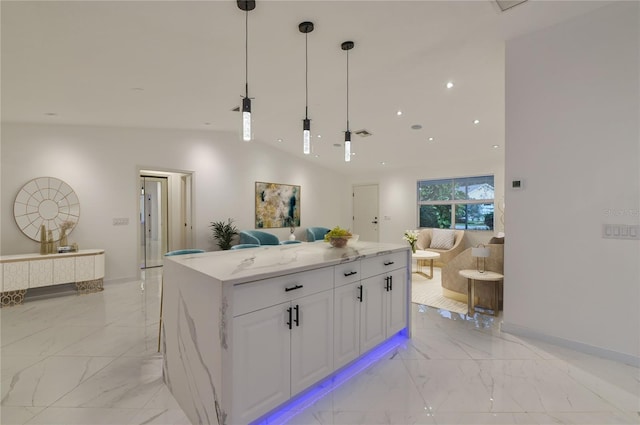 kitchen with white cabinetry, a center island, light stone counters, lofted ceiling, and decorative light fixtures