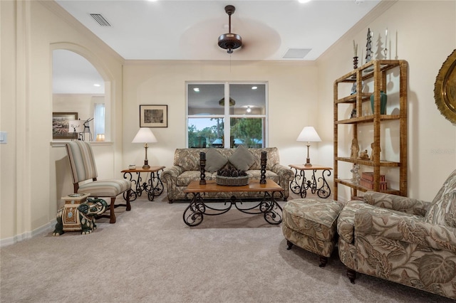 carpeted living room featuring ceiling fan and ornamental molding