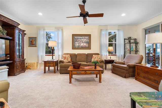 carpeted living room with ornamental molding and ceiling fan