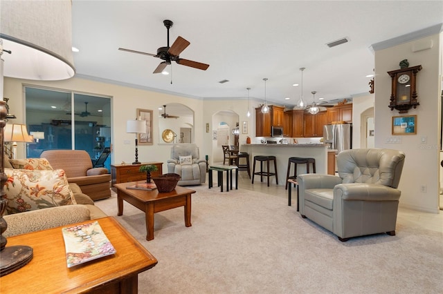 carpeted living room featuring ceiling fan and crown molding