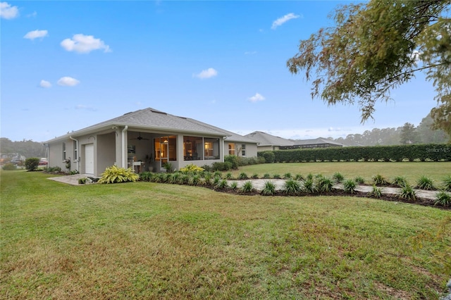 rear view of property featuring a lawn and a garage