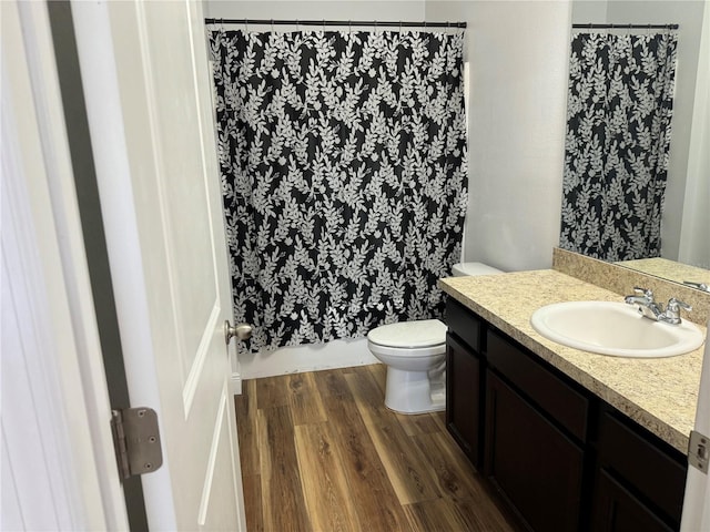 bathroom featuring a shower with curtain, hardwood / wood-style floors, vanity, and toilet