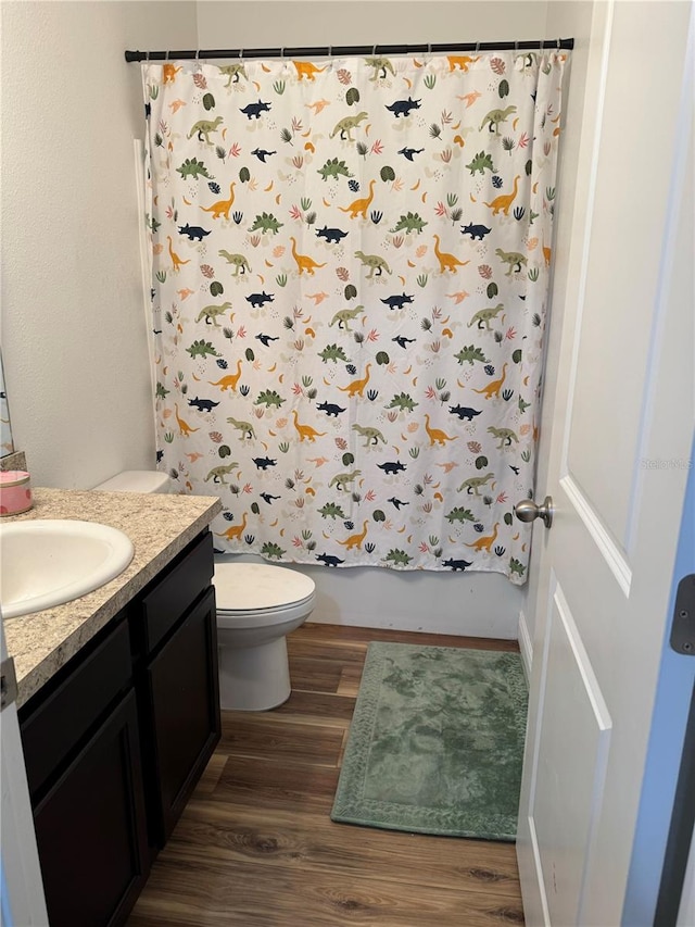 full bathroom with wood-type flooring, vanity, toilet, and shower / bathtub combination with curtain