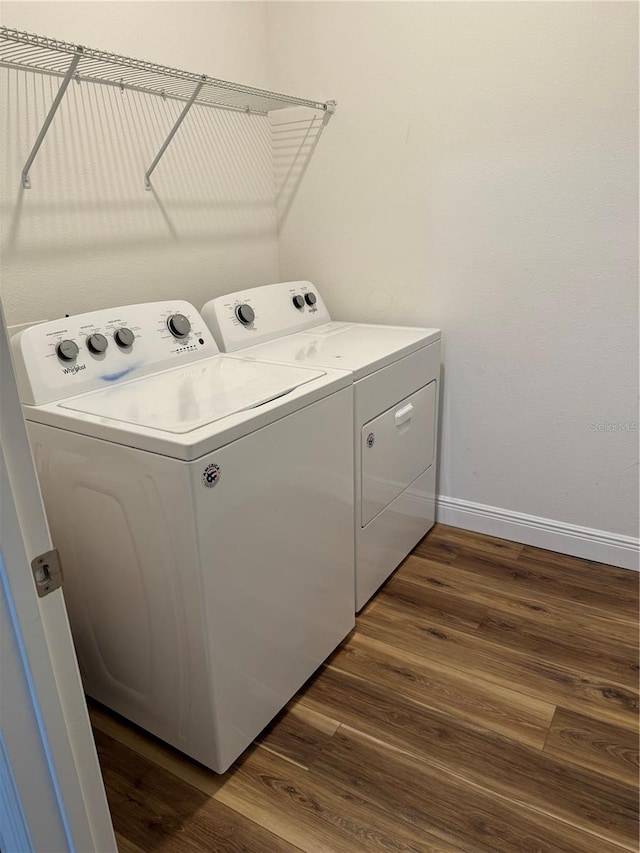 laundry area with independent washer and dryer and dark hardwood / wood-style flooring