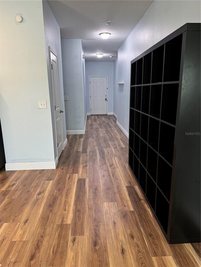 hall featuring a textured ceiling and hardwood / wood-style flooring