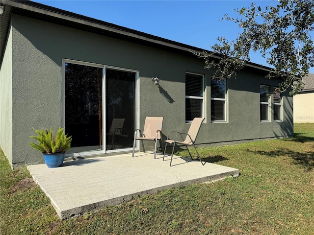 rear view of property with a lawn and a patio area