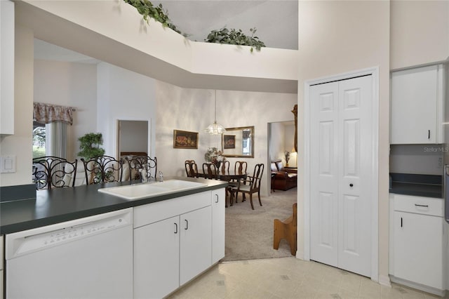 kitchen with white dishwasher, white cabinets, a towering ceiling, and sink