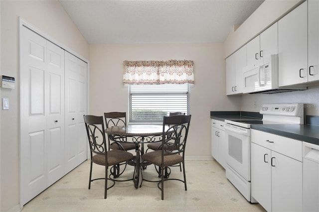 kitchen featuring white cabinets and white appliances