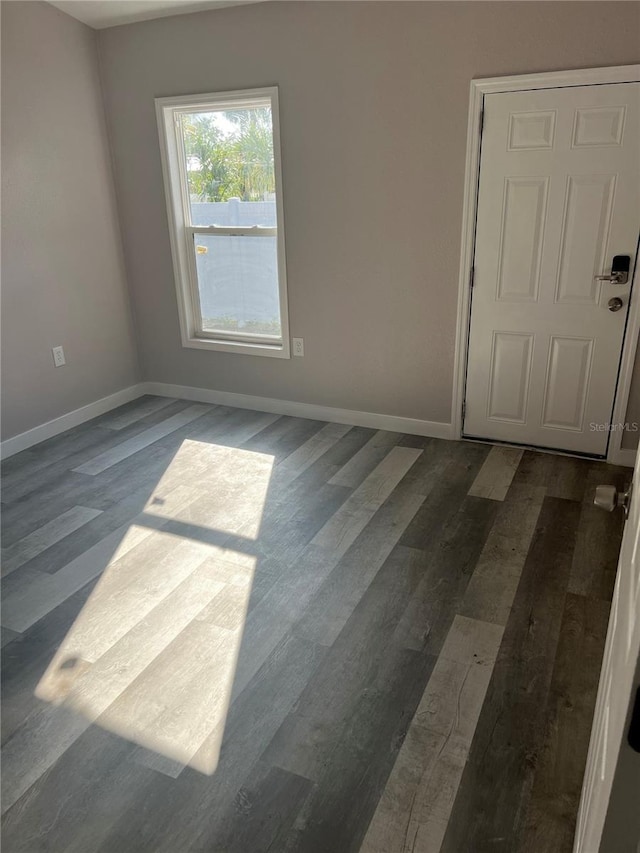 unfurnished room with dark hardwood / wood-style flooring