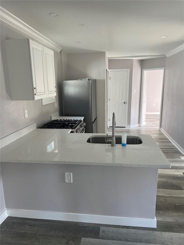 kitchen featuring stainless steel appliances, dark hardwood / wood-style floors, white cabinets, and kitchen peninsula