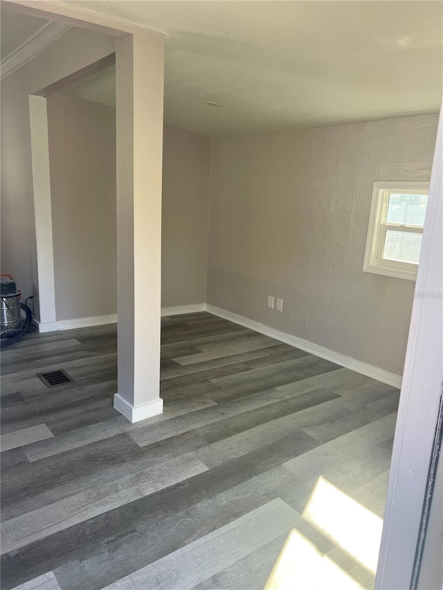 spare room featuring crown molding and dark hardwood / wood-style flooring