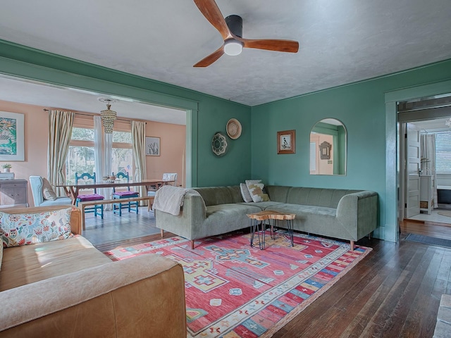 living room featuring ceiling fan and dark hardwood / wood-style floors