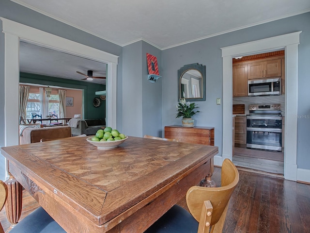 dining area featuring dark hardwood / wood-style flooring, ceiling fan, and crown molding