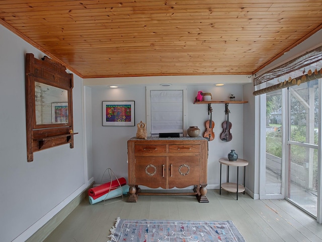 interior space with light hardwood / wood-style floors, crown molding, and wooden ceiling