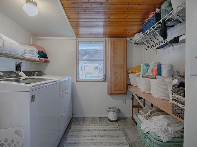 laundry area with cabinets, washing machine and dryer, wood ceiling, and light hardwood / wood-style flooring