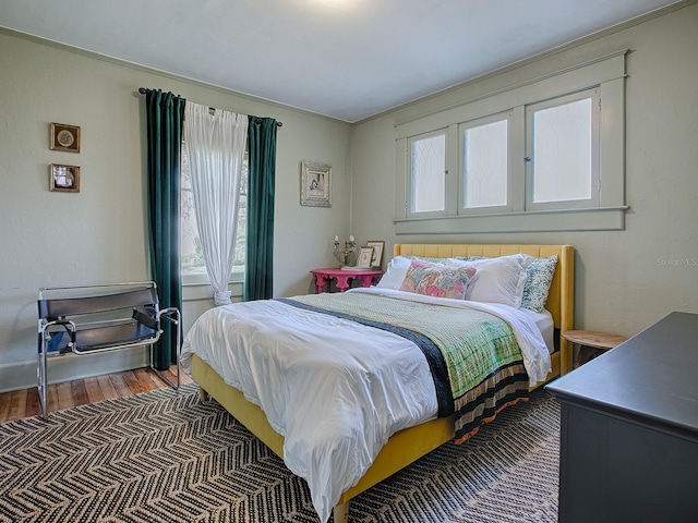 bedroom with multiple windows and wood-type flooring