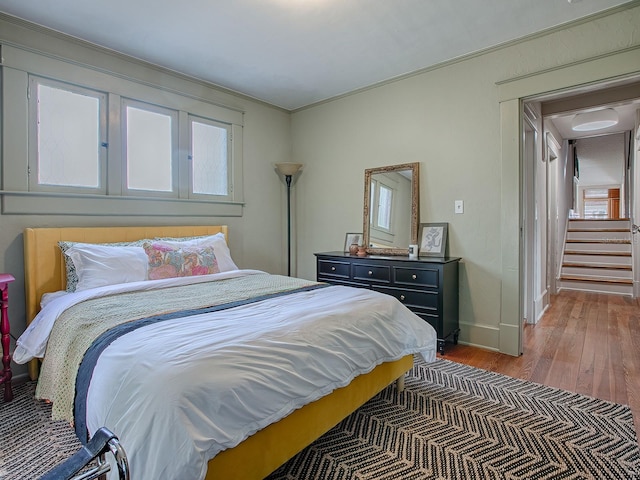 bedroom with hardwood / wood-style flooring and crown molding