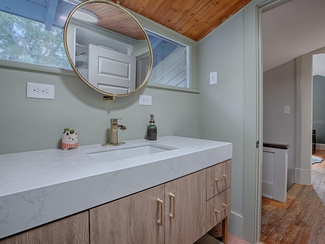 bathroom featuring vanity, hardwood / wood-style flooring, and wooden ceiling