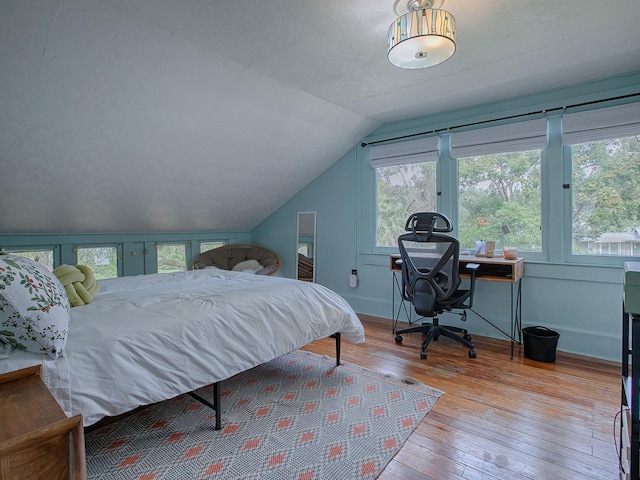 bedroom with light hardwood / wood-style flooring and lofted ceiling