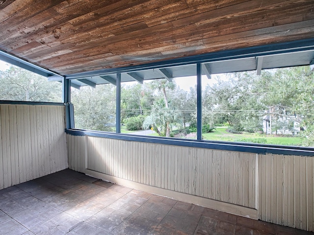 unfurnished sunroom featuring wooden ceiling and a wealth of natural light