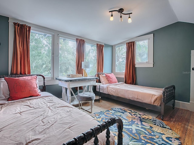 bedroom with dark wood-type flooring, multiple windows, and lofted ceiling