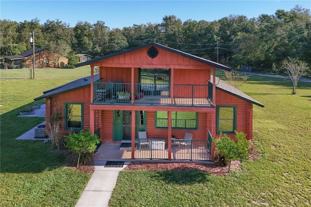 view of front of home featuring a balcony and a front yard