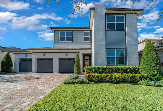 view of front of property featuring a front yard and a garage