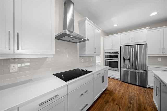 kitchen with white cabinetry, dark hardwood / wood-style flooring, wall chimney exhaust hood, and stainless steel appliances