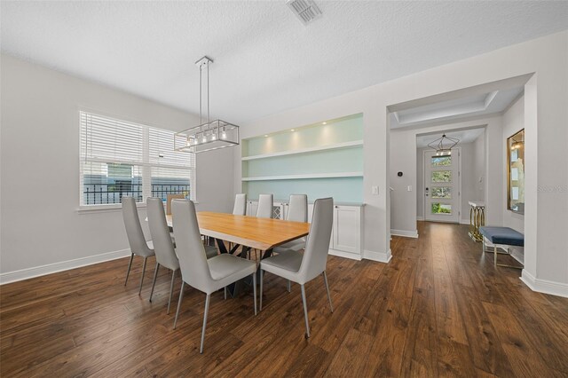 dining room with a textured ceiling and dark hardwood / wood-style floors