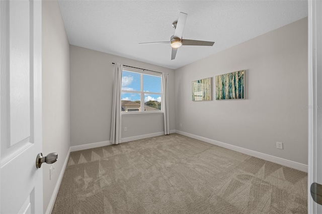 spare room with light carpet, ceiling fan, and a textured ceiling