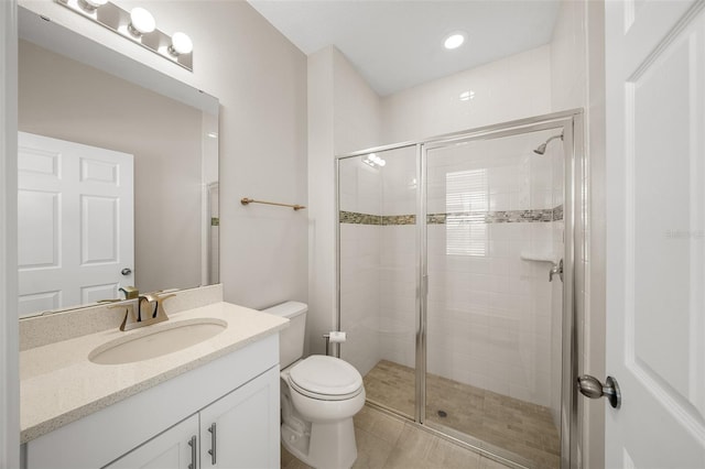 bathroom featuring tile patterned floors, vanity, toilet, and a shower with door