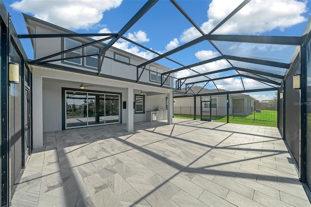 view of patio / terrace with a lanai, ceiling fan, and an outdoor kitchen