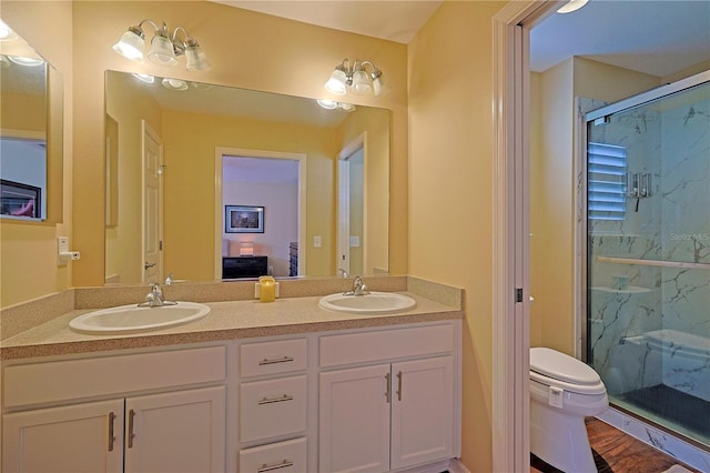 bathroom with a shower with door, vanity, and toilet