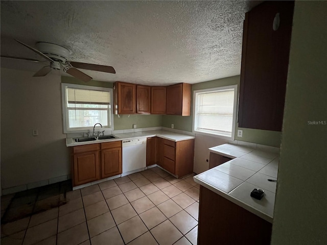 kitchen with dishwasher, light tile patterned flooring, a healthy amount of sunlight, and sink