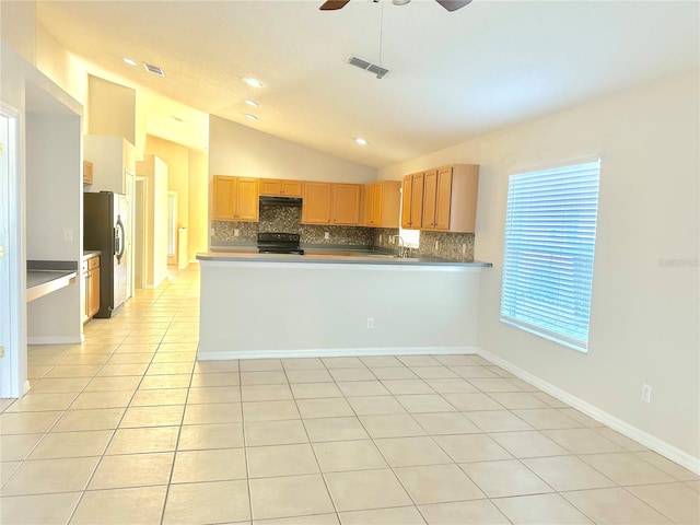 kitchen with a peninsula, black appliances, tasteful backsplash, and light tile patterned flooring